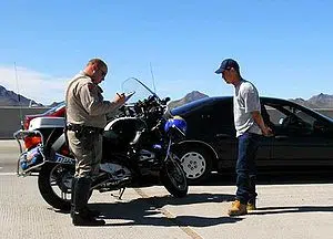 A motor officer writes a traffic ticket for a ... A motor officer writes a traffic ticket for a ...