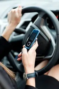 Businesswoman sending a text while driving