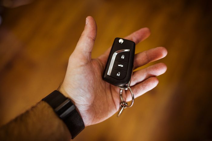 mans hand holding car keys
