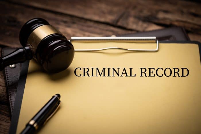 Criminal Record text on Document and gavel isolated on wooden office desk close up