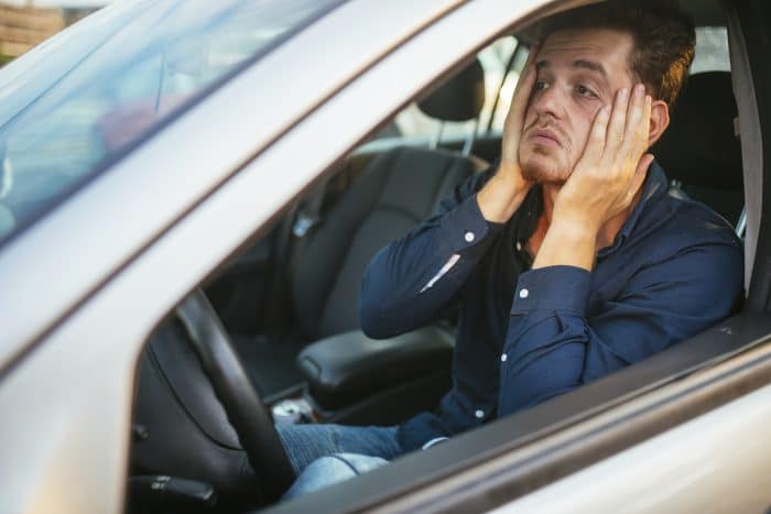 man is worried in car