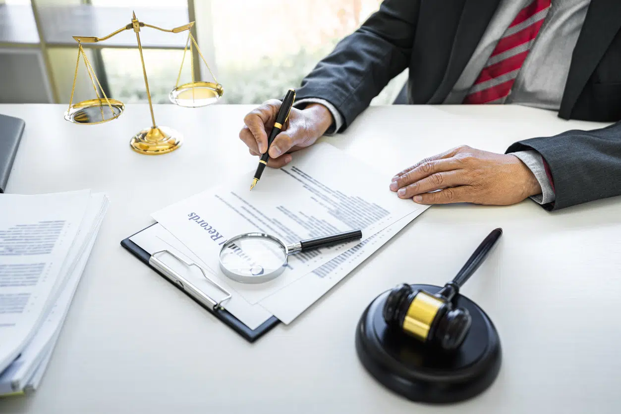 Male lawyer or judge working with contract papers, Law books and wooden gavel on table in courtroom, Justice lawyers at law firm, Law and Legal services concept.