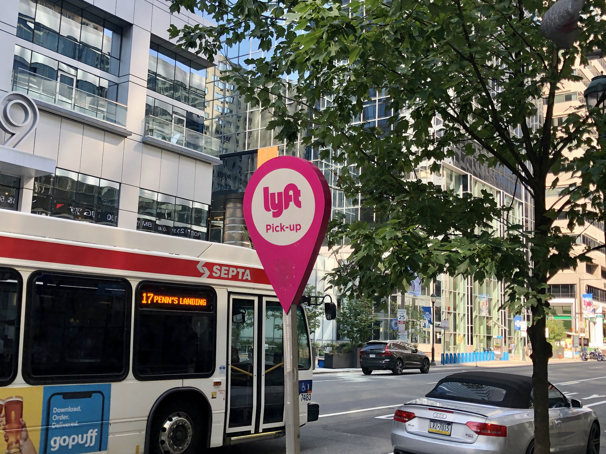 Philadelphia, Pennsylvania United States - August 31 2021: Lyft mobile app ride sharing sign for a pickup station with bus.