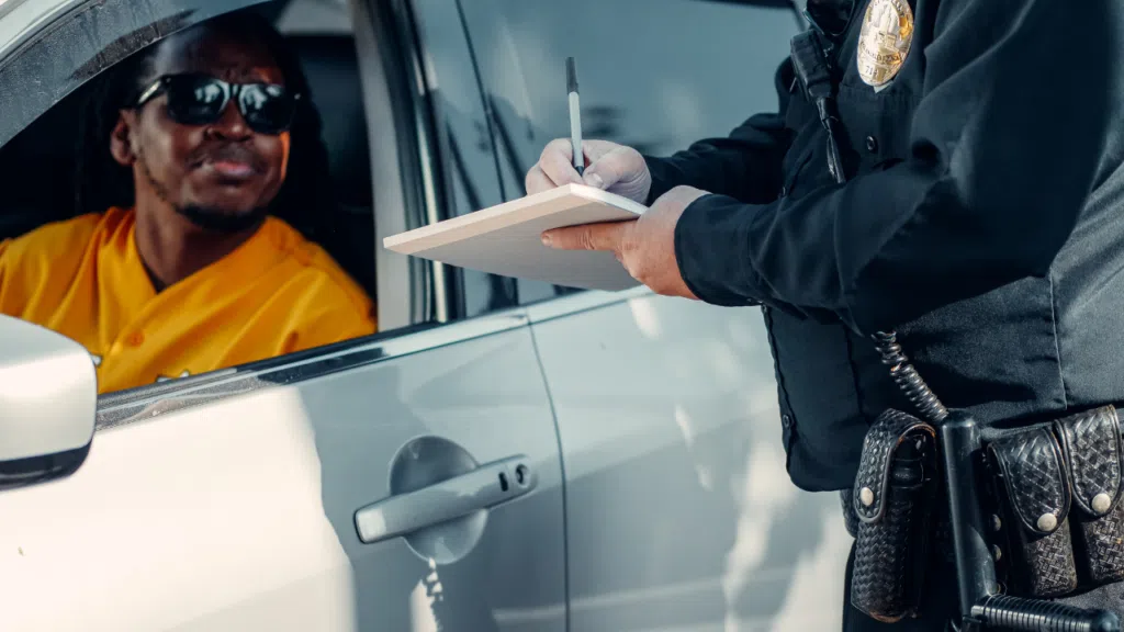 A police officer giving a speeding ticket to a driver in NY.